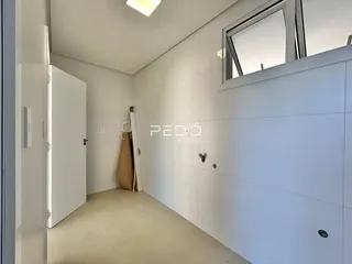 Interior de um ambiente com paredes brancas e piso claro.