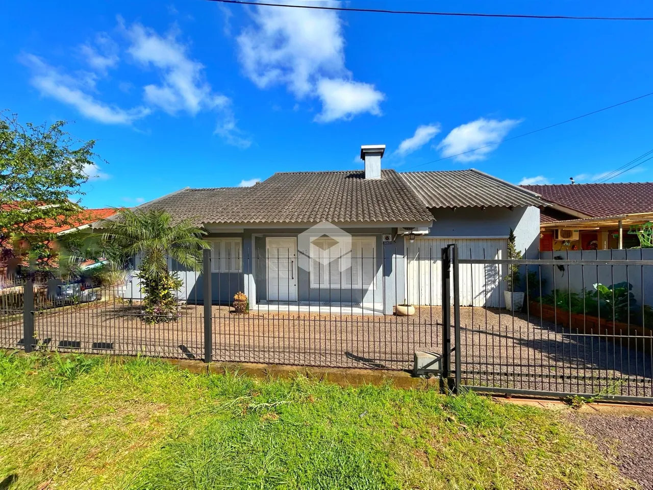 Fachada de uma casa em Lajeado, Brasil, com cerca e jardim.