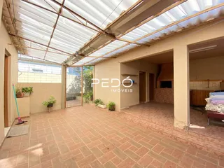 Área comum com piso de tijolo e estrutura de teto exposta.