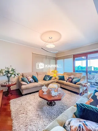 Sala de estar com dois sofás e uma mesa de centro em um ambiente bem iluminado.