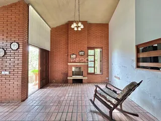 Ambiente interno com paredes de tijolo aparente e piso de cerâmica.