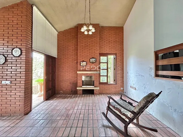 Ambiente interno com paredes de tijolo aparente e piso de cerâmica.