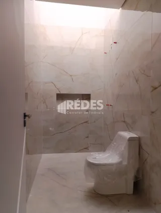 Um banheiro com revestimento em mármore claro.