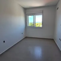 Ambiente interno com paredes brancas e uma janela iluminada.