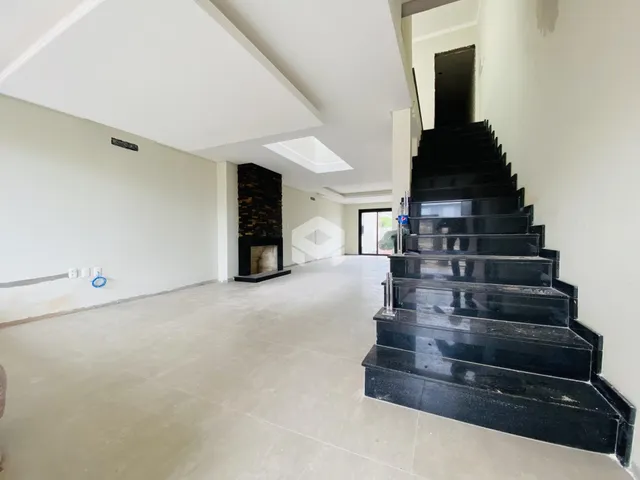Hall de entrada com escadaria de mármore preta e parede de lareira.