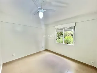 Ambiente interno de uma sala ampla com paredes brancas e piso claro.