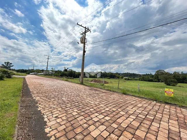 Uma estrada de paralelepípedos corre ao longo de um campo gramado com cerca.