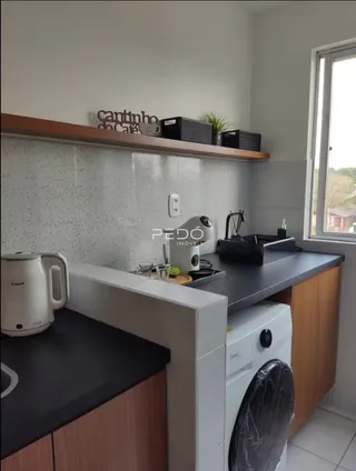 Foto de uma cozinha com armários e máquina de lavar roupa.