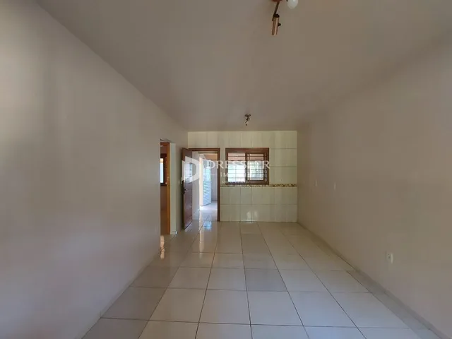 Corredor interno de uma residência com piso de cerâmica clara.