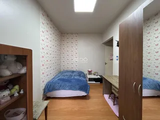 Quarto com parede estampada e piso de madeira em um imóvel no Brasil.