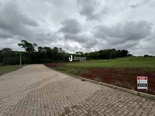 Vista da propriedade com acesso por estrada e campo aberto.