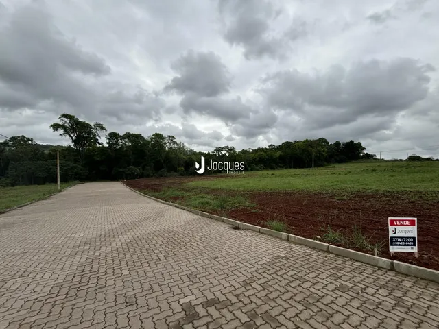 Vista da propriedade com acesso por estrada e campo aberto.