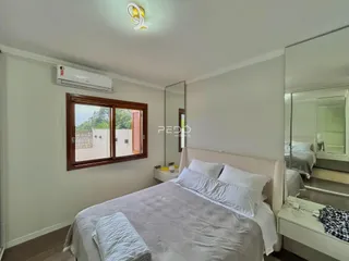 Quarto com cama e janela em ambiente claro.