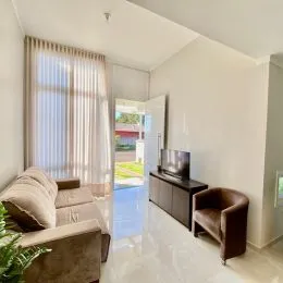 Uma sala de estar clara com sofá e janela.