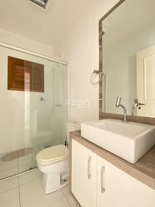 Foto do interior de um banheiro com piso cerâmico branco.