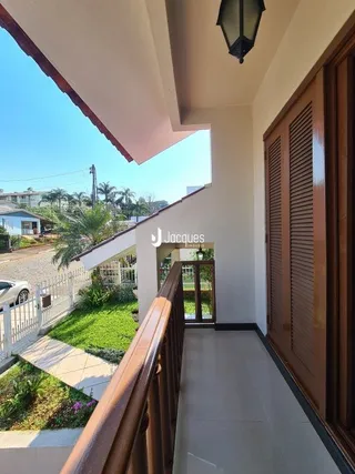 Vista interna de um corredor com acabamentos em madeira em uma residência.