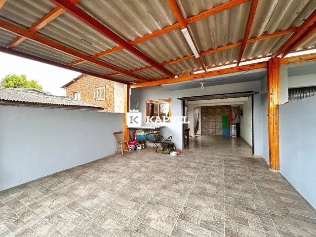 Vista interna de um espaço amplo com piso de cerâmica e estrutura de madeira exposta.