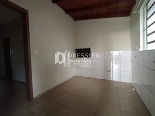 Vista interna de um ambiente com piso de cerâmica e teto de madeira aparente.