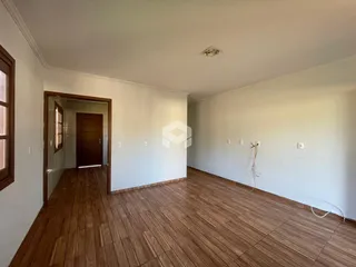 Ambiente interno com piso de madeira e paredes brancas.