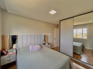 Quarto com cama e porta de vidro refletindo a vista externa.