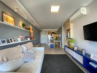 Sala de estar moderna com sofá e prateleiras em um apartamento.