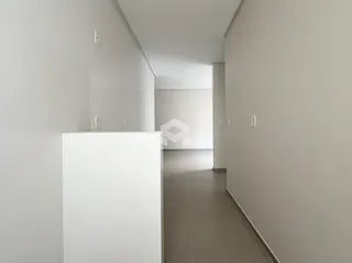Corredor interno de uma residência moderna com paredes brancas.
