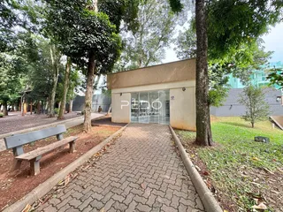 Vista da fachada de uma residência em Lajeado, Brasil, cercada por árvores e um caminho de pedras.