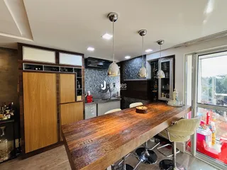 Cozinha moderna com ilha de madeira e armários em tom de madeira.