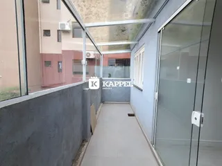 Vista de um corredor com paredes cinzas e estrutura de vidro em um imóvel em Lajeado.