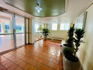 Sala de estar com piso de tijolos vermelhos e portas de vidro.