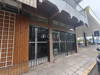 Fachada de uma residência em Lajeado, Brasil, com portão de ferro e área coberta.
