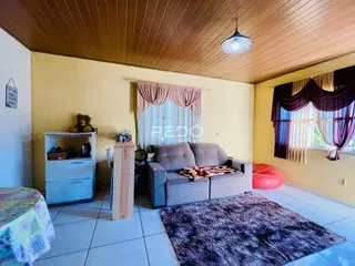 Sala de estar com teto de madeira e cortinas na sala em Lajeado.