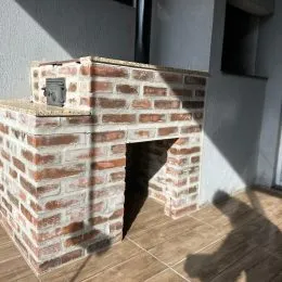 Estrutura de tijolos com abertura de lareira em uma parede.