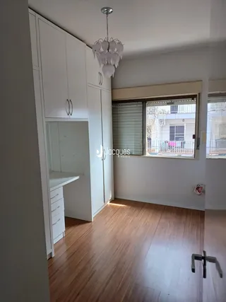 Interior de um cômodo com armários embutidos e piso de madeira.