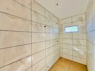 Parede interna com revestimento de cerâmica e janela.