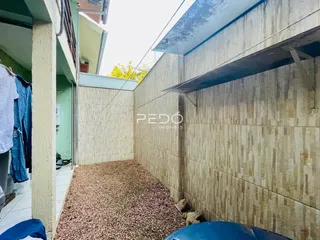 Parede lateral de uma residência com piso de cascalho em Lajeado.