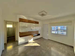 Sala de estar com painel de madeira e piso de cerâmica.
