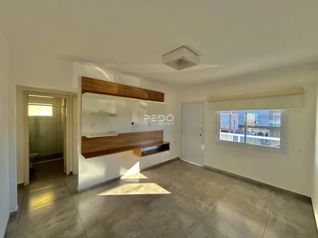 Sala de estar com painel de madeira e piso de cerâmica.