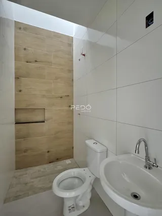 Banheiro moderno com revestimento de madeira e cerâmica nas paredes.