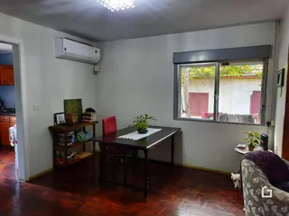 Sala de estar com piso de madeira e janela.