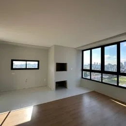 Sala de estar com piso de madeira e grandes janelas que oferecem uma vista.