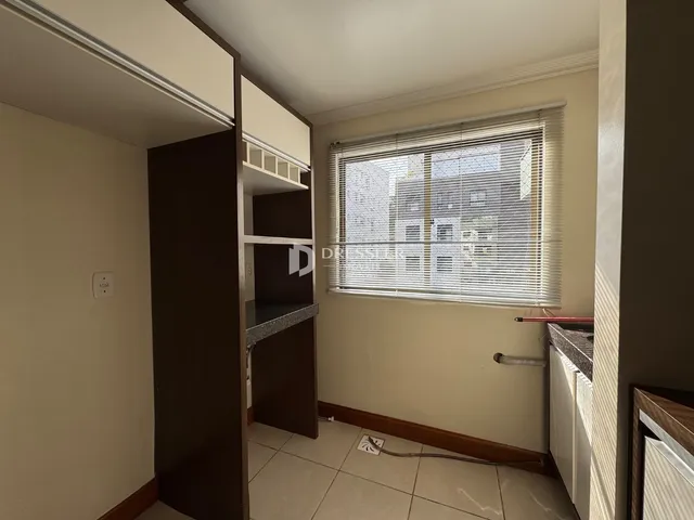Foto de um corredor interno com piso de cerâmica e armários em uma residência.
