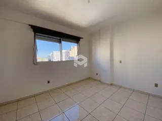 Ambiente interno com piso de cerâmica e janela de grande porte.