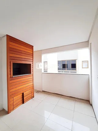 Sala de estar com parede de madeira e piso de cerâmica clara.