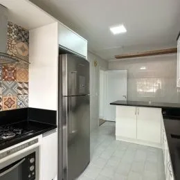 Foto de uma cozinha com armários brancos e piso de cerâmica.