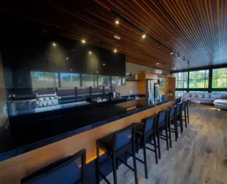 Vista de uma cozinha moderna com balcão longo e iluminação em madeira.