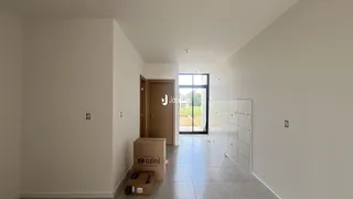 Hall de entrada com paredes brancas e piso claro.