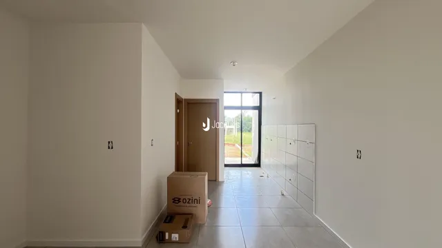 Hall de entrada com paredes brancas e piso claro.