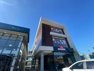 A fachada moderna do edifício Bazar 77 em Lajeado, Brasil, sob um céu azul.