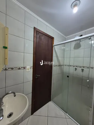 Foto de um banheiro com azulejos brancos e uma bancada.